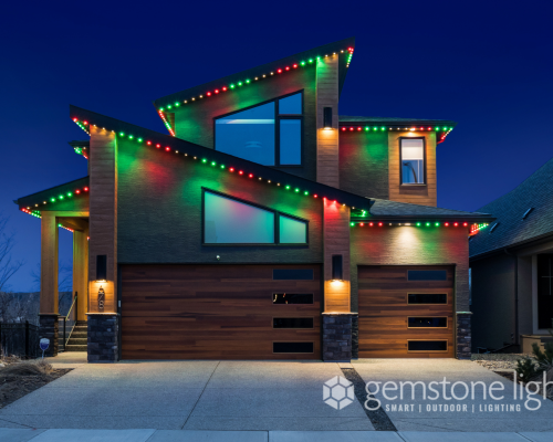 Modern house decorated with colorful Christmas lights on its roof and garage at night, showcasing innovative outdoor lighting solutions by Halo Lighting.